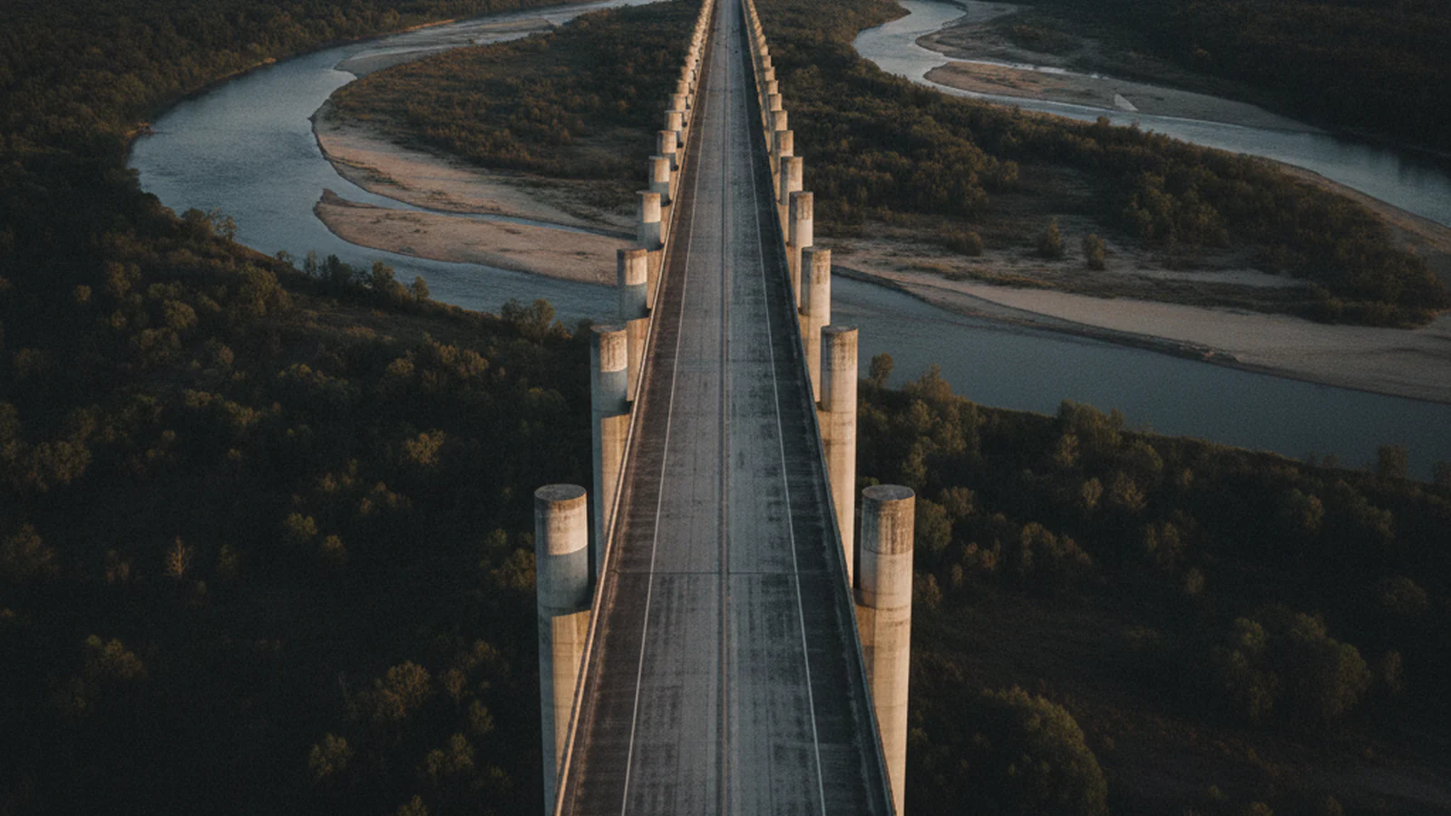Concrete road bridge on tall piers crossing a river valley