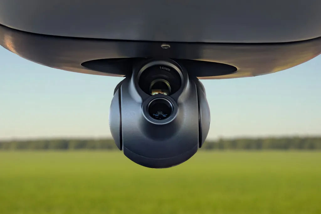 EO/IR gimbal with a thermal camera mounted under the Nimbus Recon fuselage, open field behind