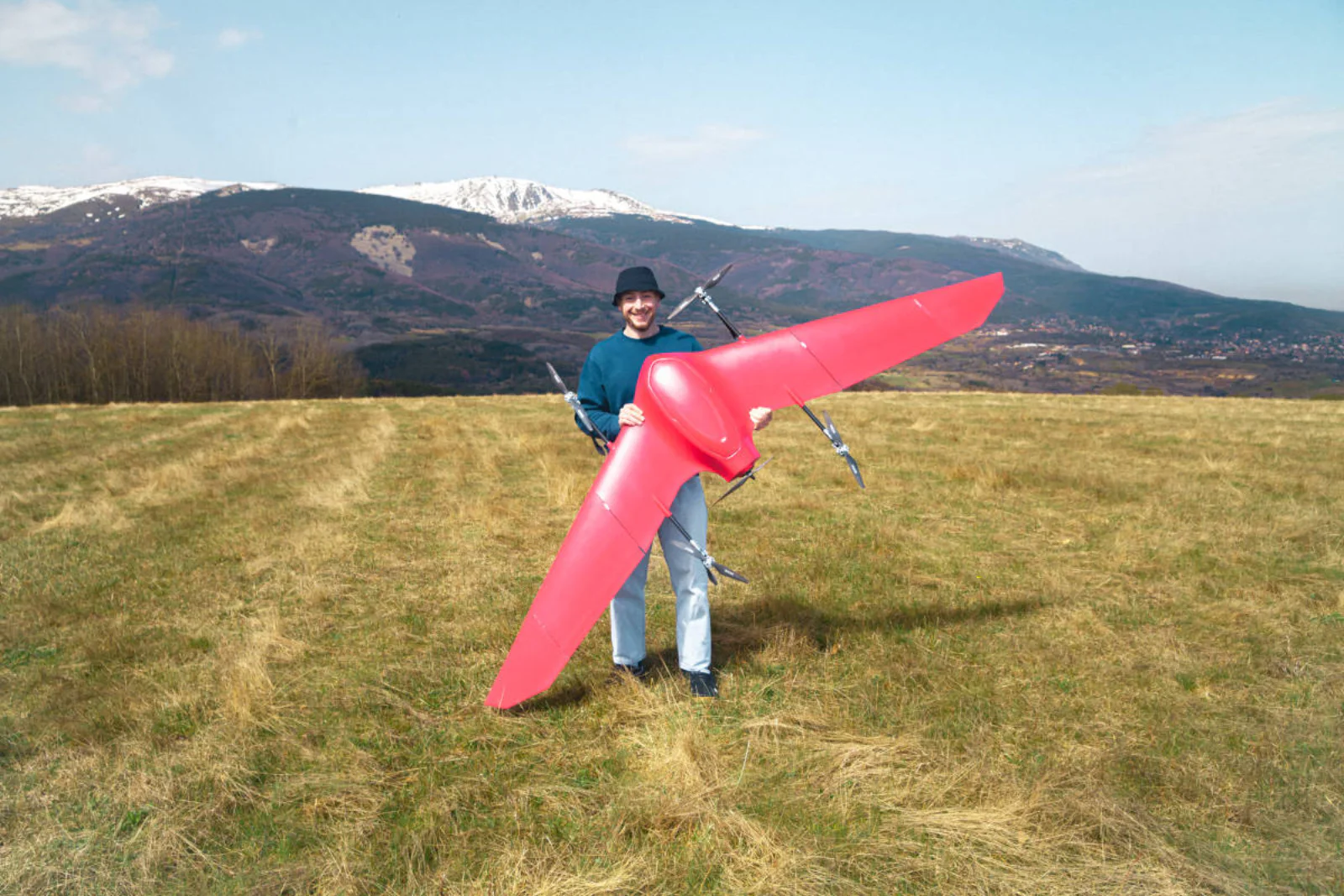 One operator carrying Nimbus at full wingspan across an open field
