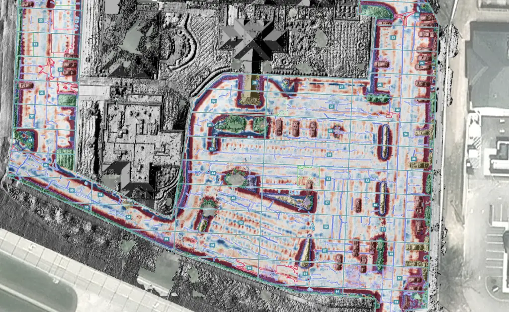 The whole parking lot in HALO AI's relief view: depressions, curbs and islands stand out in red, cracks traced in blue, numbered sample units, surroundings in grayscale